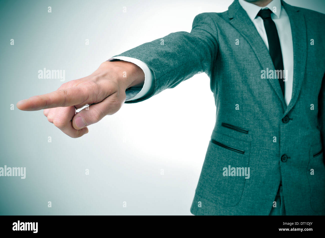 a man wearing a suit pointing with the finger the way out Stock Photo