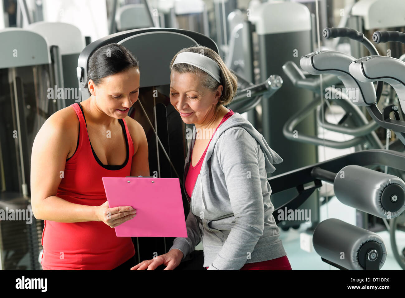Personal trainer with senior woman at gym Stock Photo - Alamy
