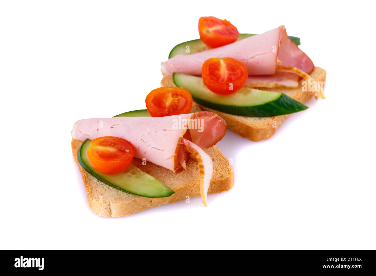 Rusk sandwiches with tomato, cucumber and pork loin isolated on white background. Stock Photo