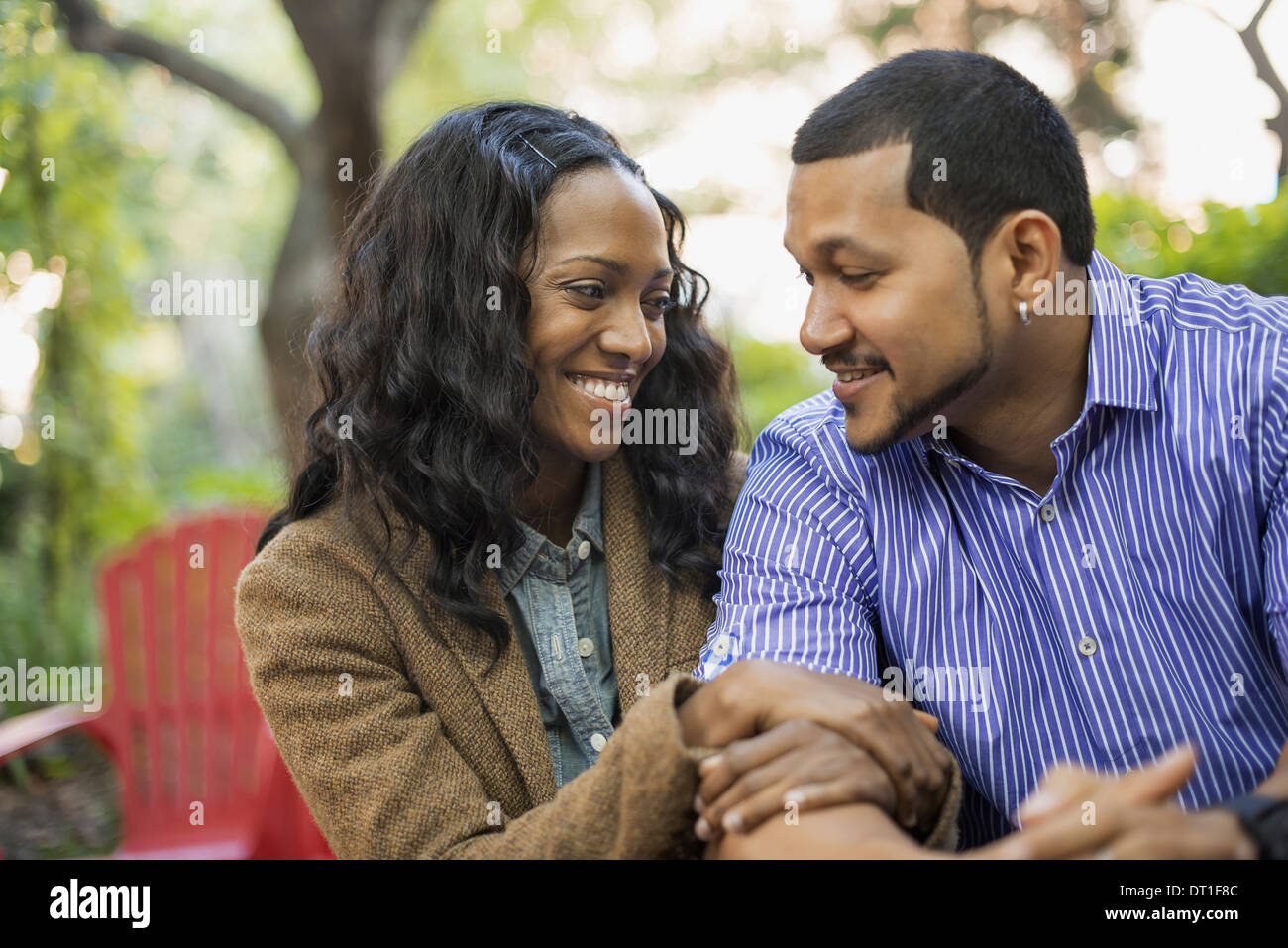 Scenes from urban life in New York City A man and a woman a couple with linked arms sitting side by side Stock Photo