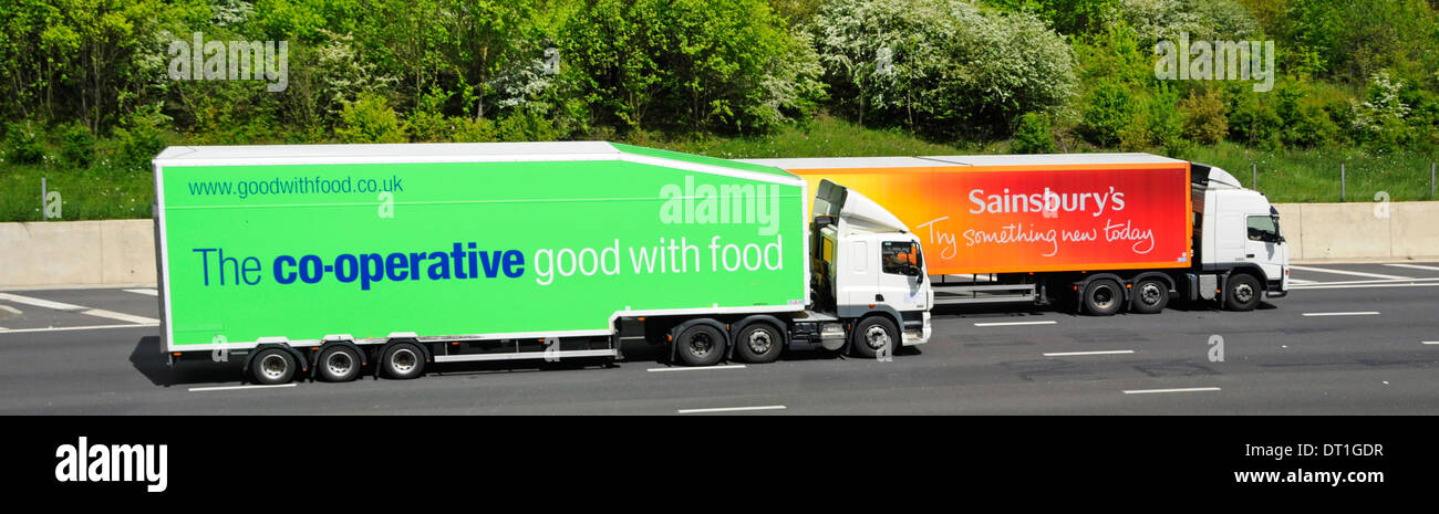 Sainsburys supermarket lorry being overtaken by Co op food supply chain store delivery hgv truck & articulated trailer driving along UK motorway Stock Photo