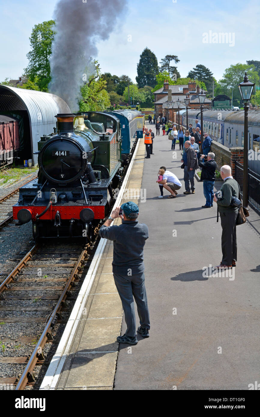 Railway enthusiasts on the platform at Ongar watching steam locomotive 4141 on the Epping Ongar heritage line Stock Photo