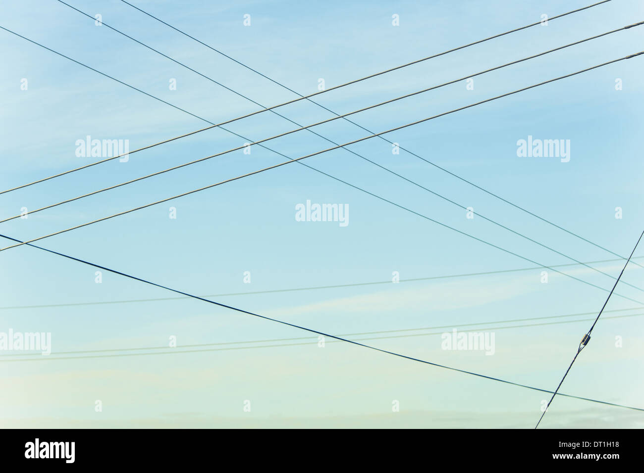 Power lines overhead criss crossing in the air at Belridge in California Stock Photo