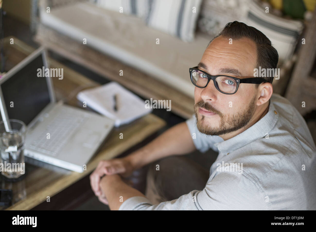 A man sitting at a desk using a laptop computer Running a small business Stock Photo