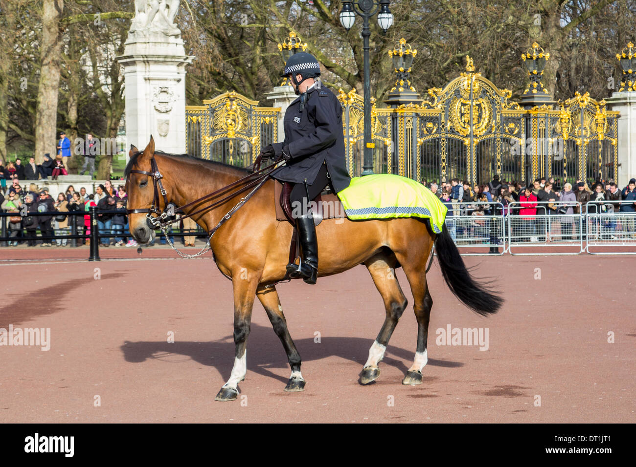 LONDON, UK, 2ND FEB 2014: A Police Man on horseback outside Buckingham Palace keeping an eye on the crowds of people Stock Photo