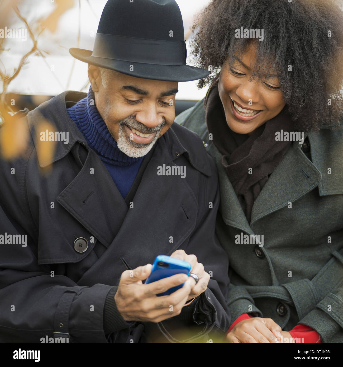 Two people a man and woman standing side by side keeping in contact using mobile phones Stock Photo