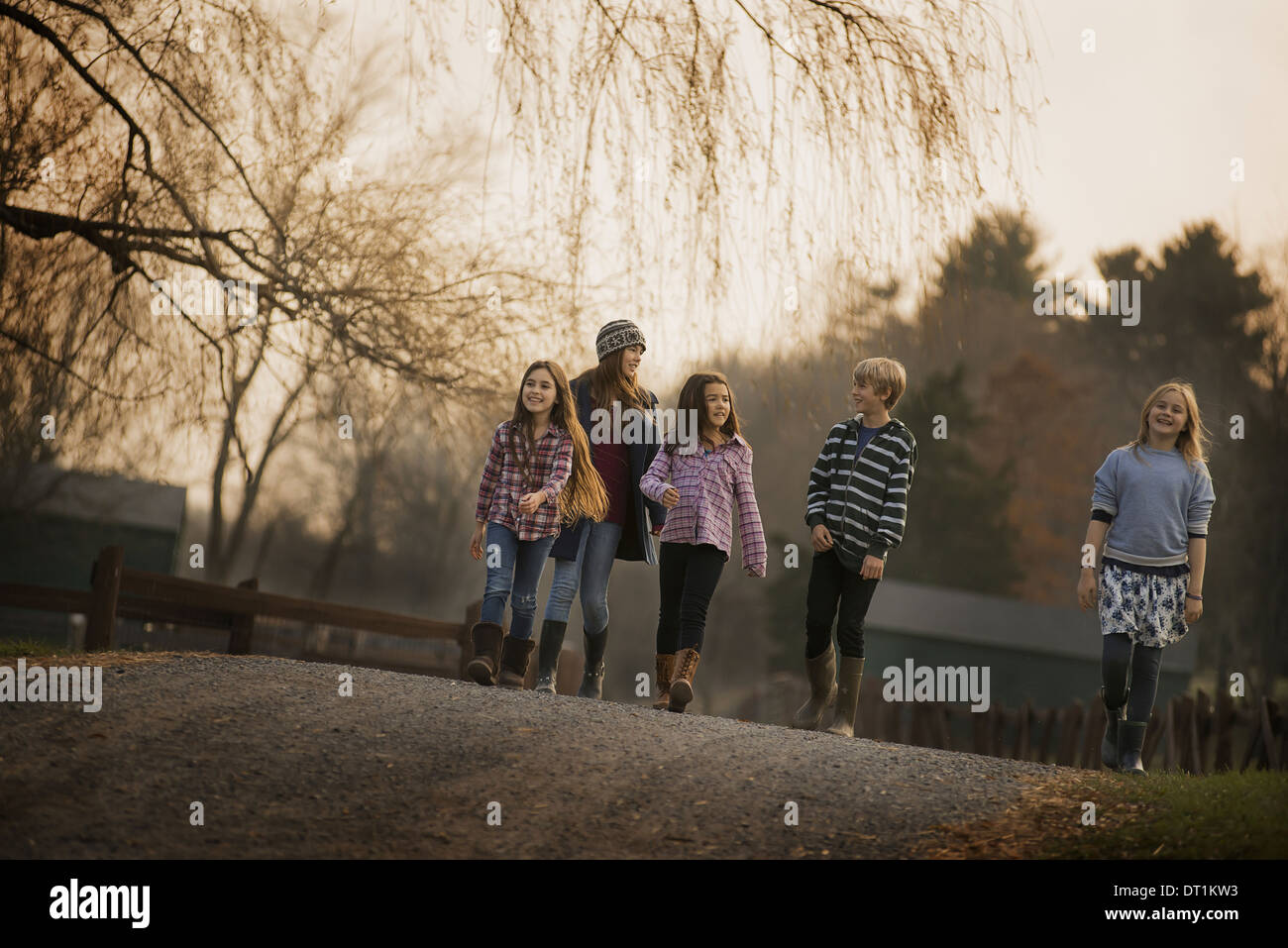 A group of children a boy and four girls walking along a path on a winter's day An organic farm Stock Photo