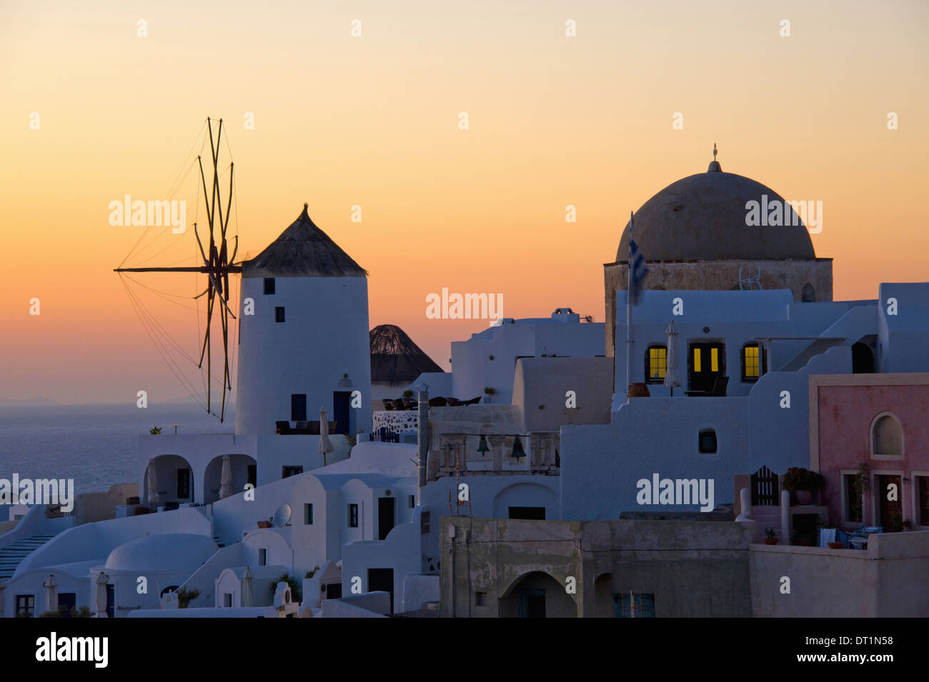 The historic white washed houses windmills and domed church of Oia town on Santorini island Stock Photo
