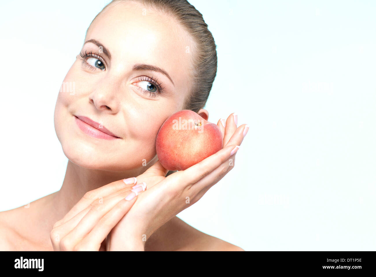 Young woman with peach Stock Photo