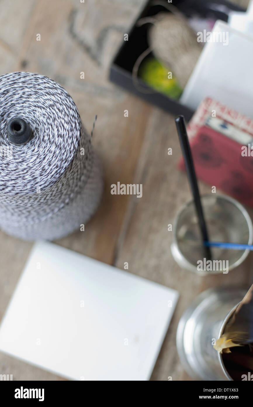 A table top with a small group of objects Tankard and pencils paper and a large ball of string Stock Photo