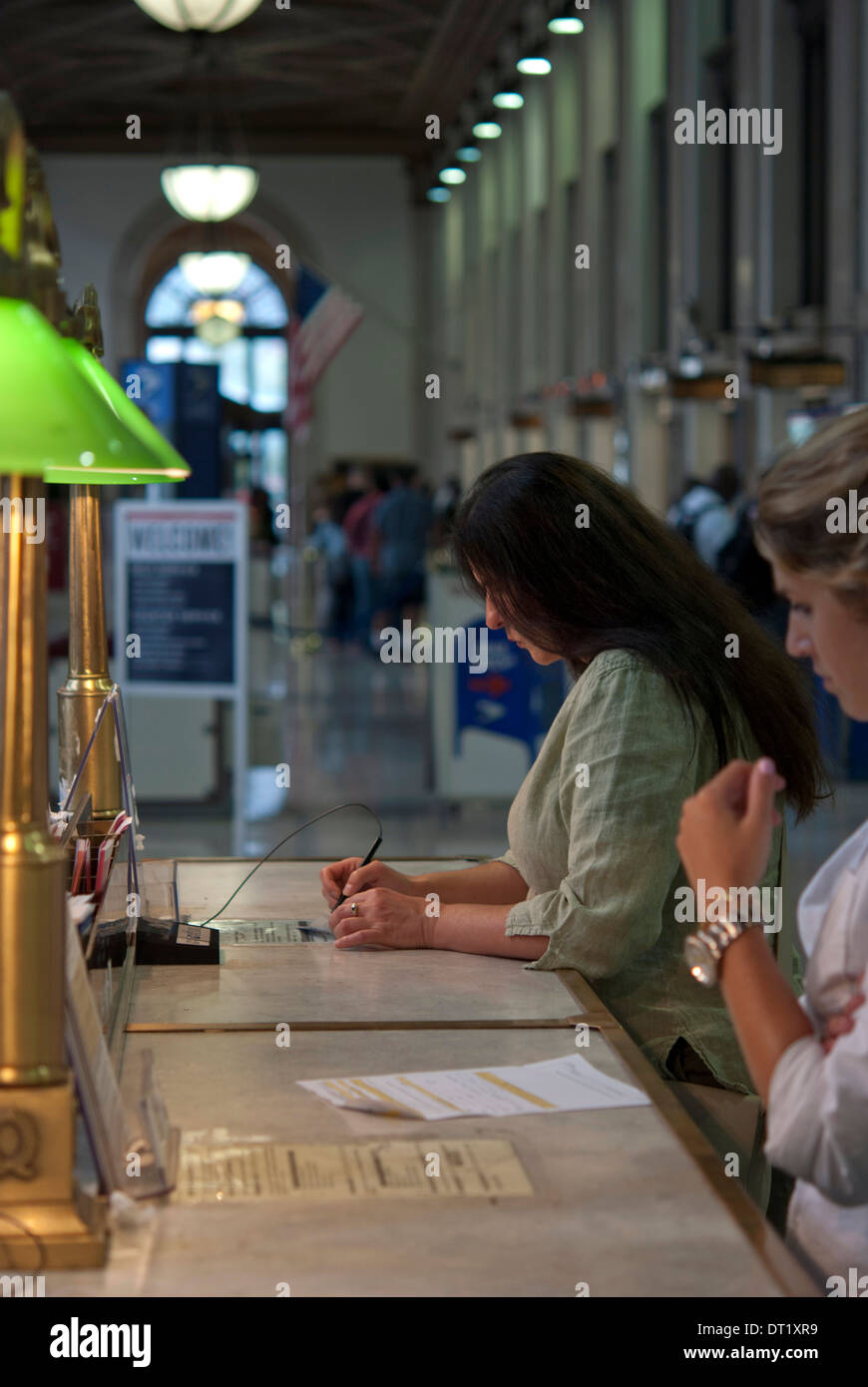 Woman filling in forms at New York post office Stock Photo