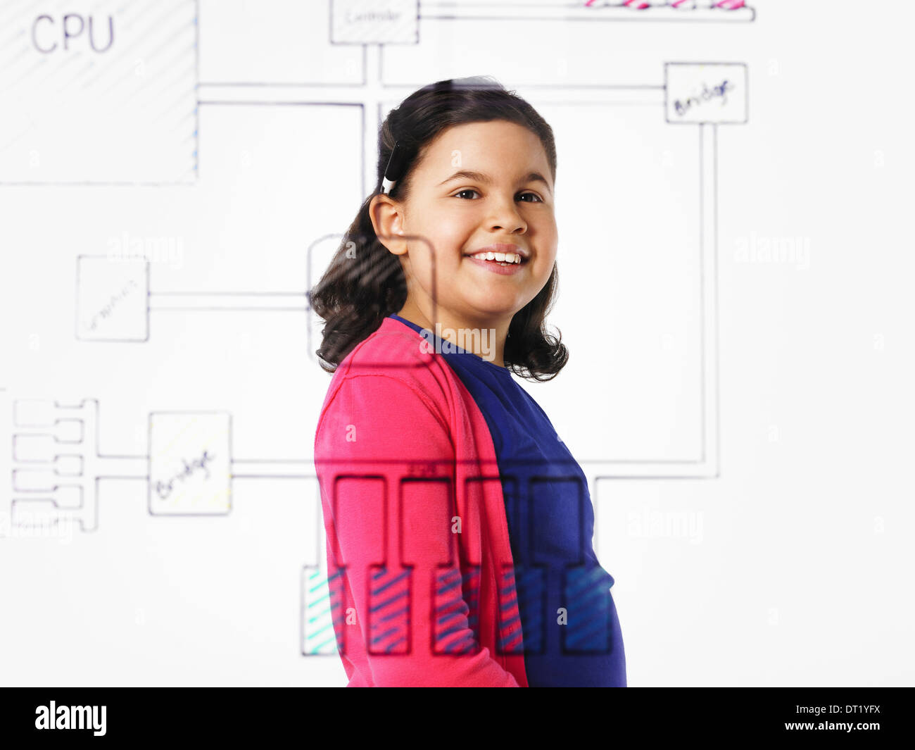 A young girl looking at a drawing of a computer motherboard circuit drawn on a see through clear surface Stock Photo