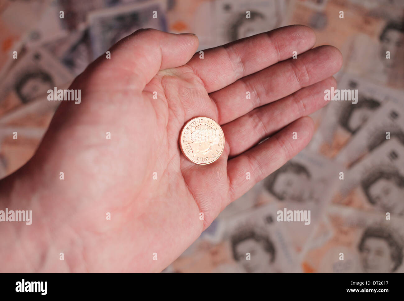Two pence coin in a man's hand. Stock Photo