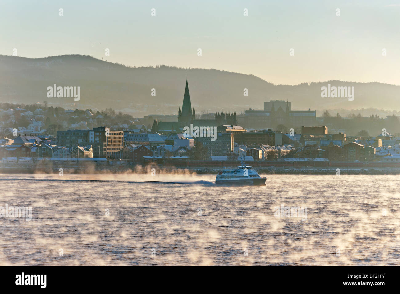 Mist rises from the sea, as the Winter sun hits the water at the city of Trondheim, Norway Stock Photo