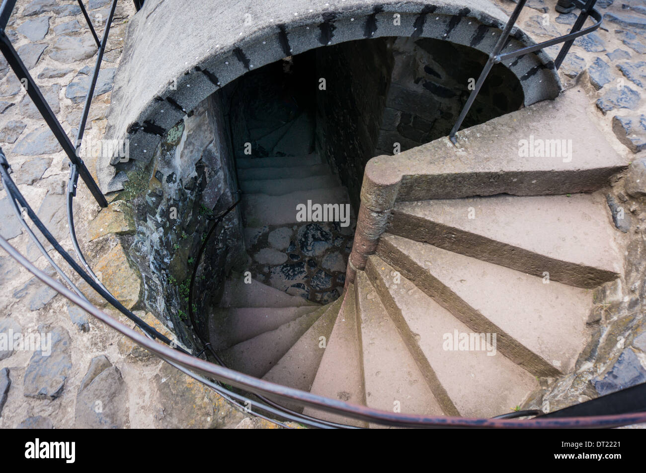 A winding stone staircase leading down into the depths of a tower Stock Photo