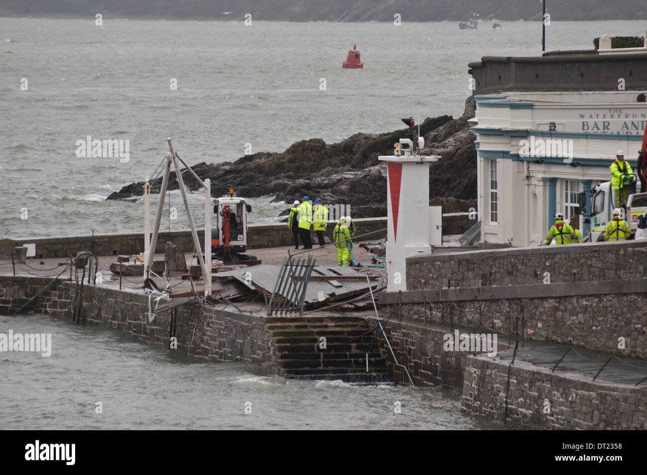 Plymouth, Devon, UK. 6th February 2014. The waterfront pub decking and entrance are demolished by giant waves during a storm, leaving council workers to try and clear up the debris before the next storm surge. Credit:  Anna Stevenson/Alamy Live News Stock Photo