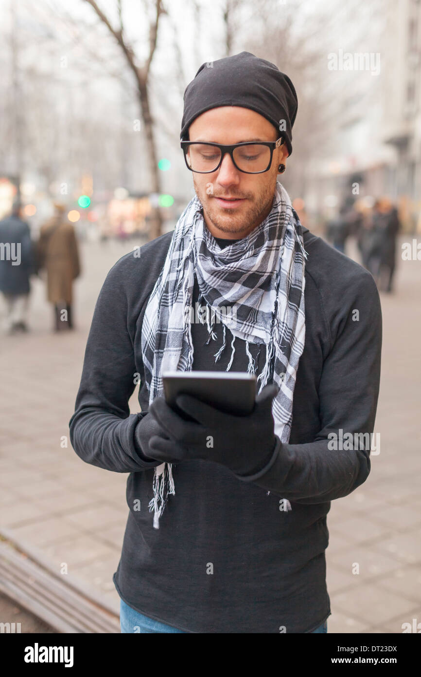 Young man reading messages and information using an i-pad tablet computer. Stock Photo