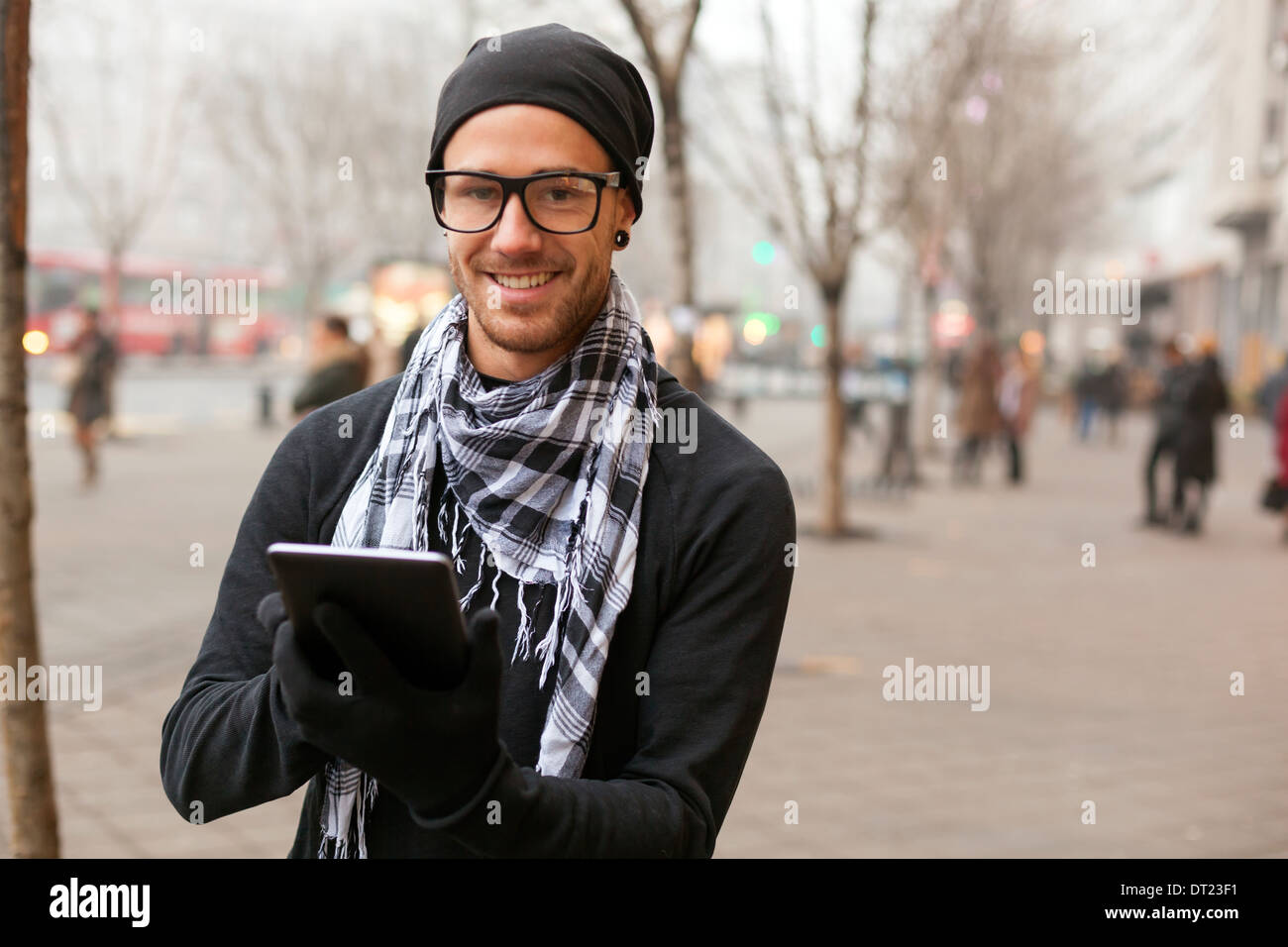 Young man reading messages and information using an i-pad tablet computer. Stock Photo