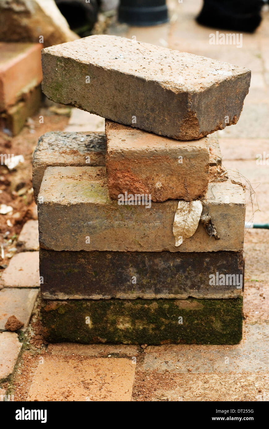 Pile or stack of old used bricks on paving. Stock Photo
