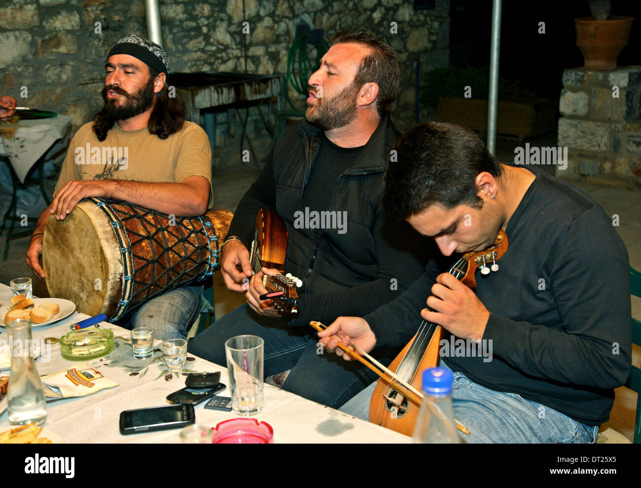 Musicians in a "Rakokazano" ("Raki distillation") in Fourni village, Epano Mirabello, Lasithi, Crete, Greece. Stock Photo