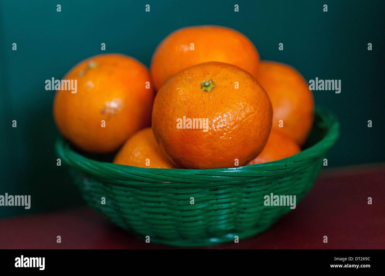Tangerines in a small green basket Stock Photo