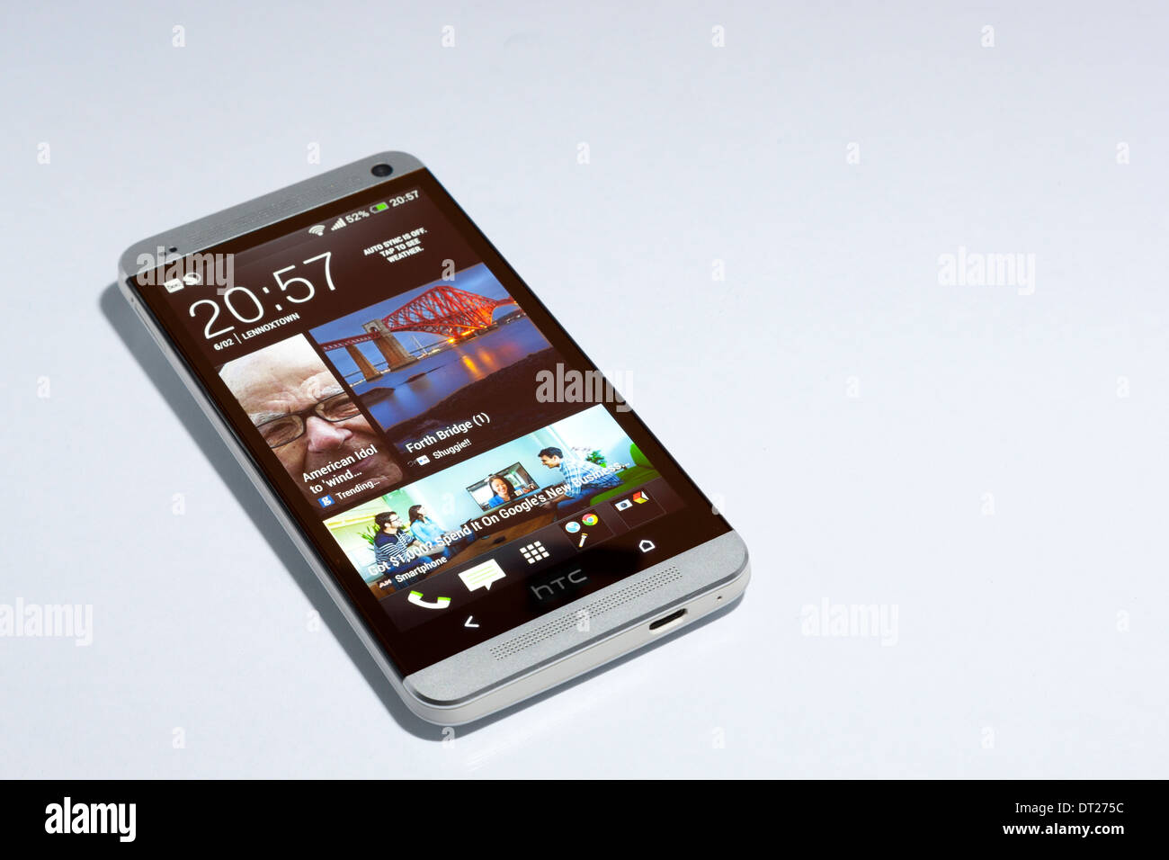 HTC One smartphone, silver, with Blinkfeed on the screen. White background. Stock Photo