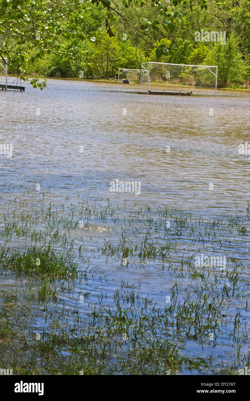 A river floods a soccer field in Spring Stock Photo