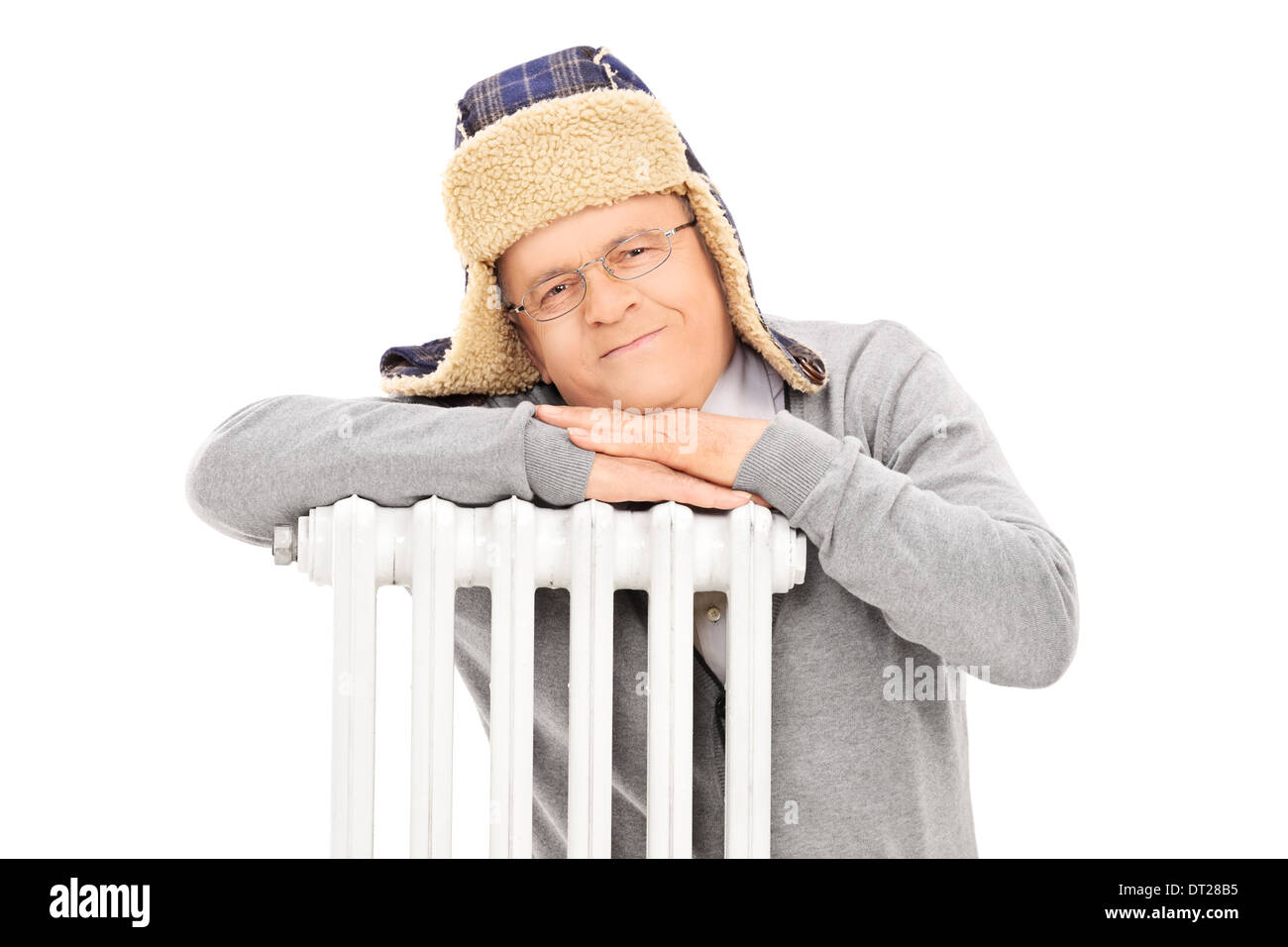 Middle aged man with winter hat leaning on a radiator Stock Photo