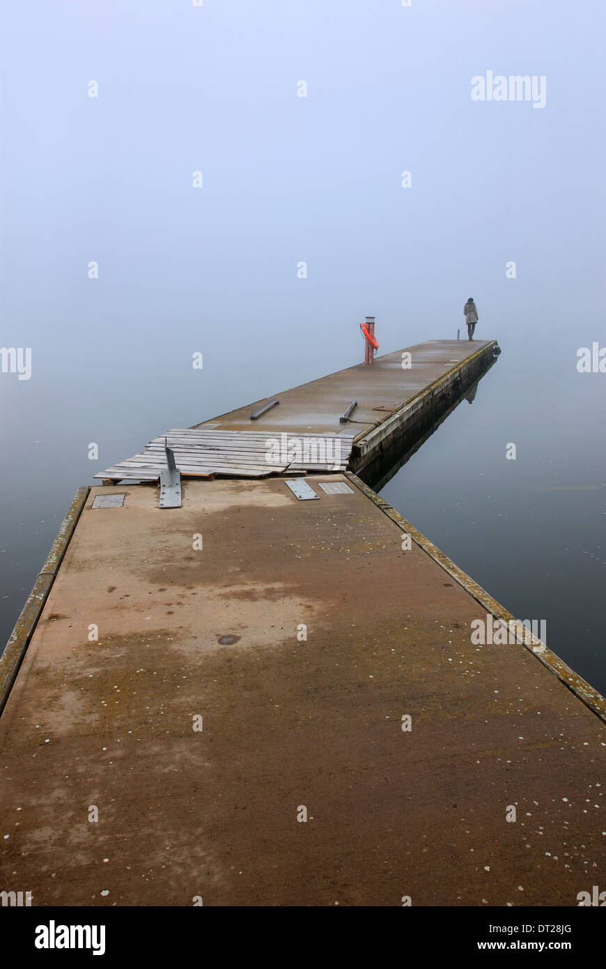 Lonely woman on the dock of the small fishing port of Agios Achilleios islet, Mikri Prespa lake, Florina, Macedonia, Greece. Stock Photo