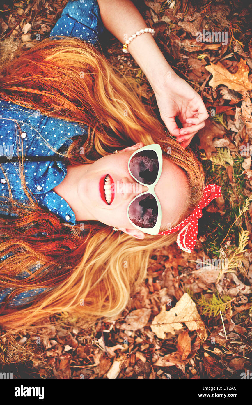 Portrait of young woman lying down on ground Stock Photo