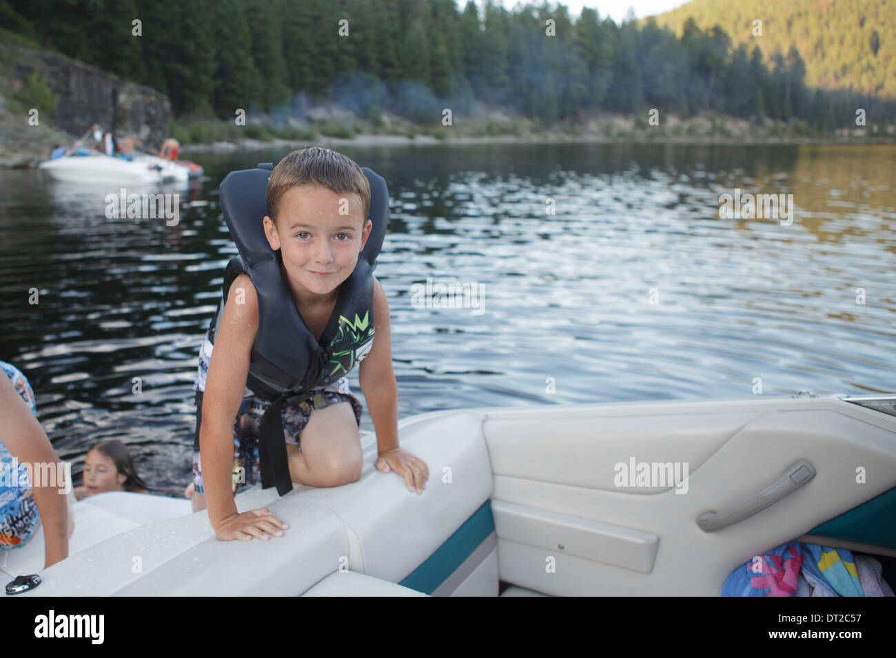 little boys peeing boat Boy on the beach playing with a toy wooden boat in the water ...