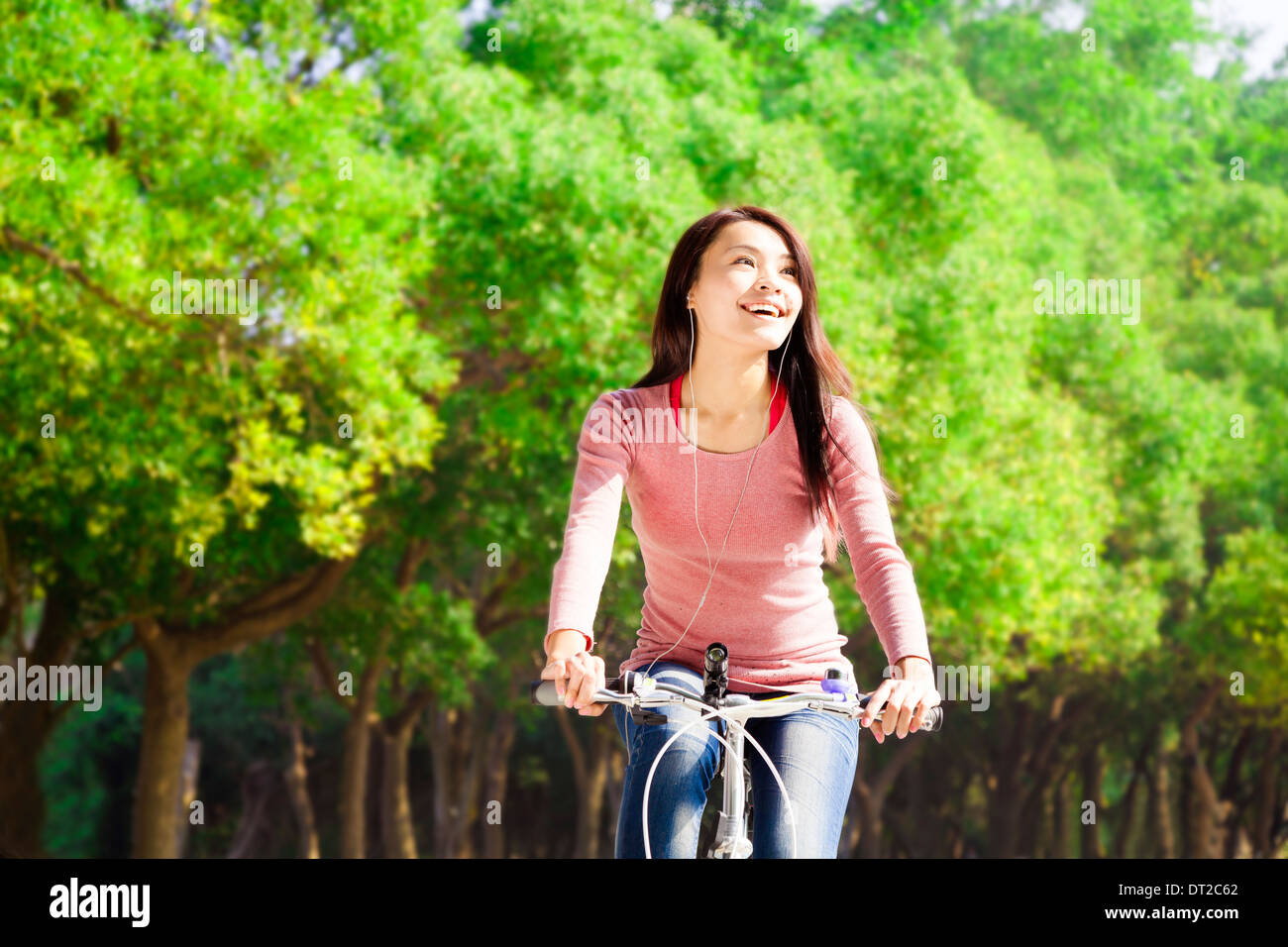 Pretty asian young woman riding bike in the park Stock Photo