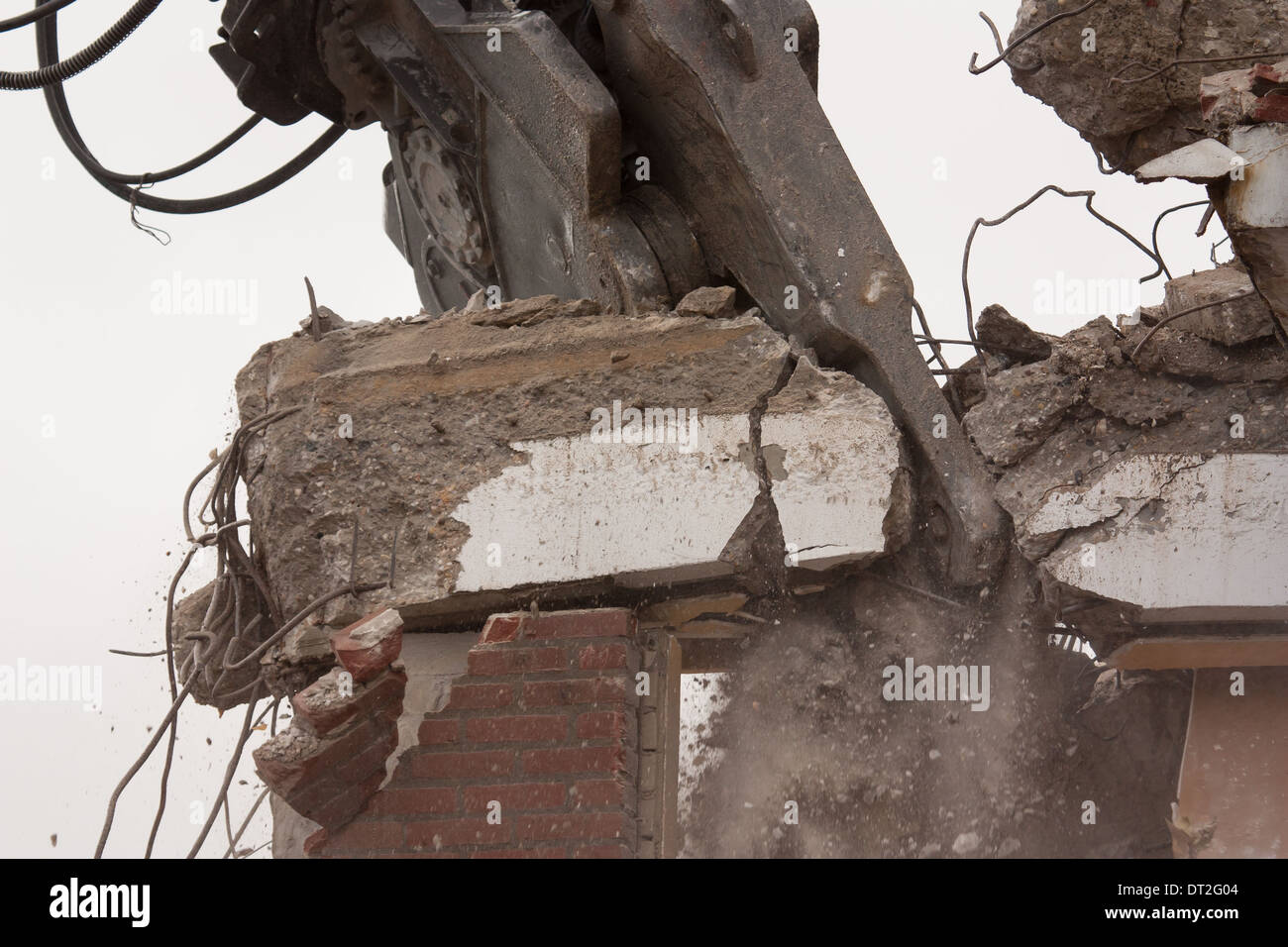 A crane is demolishing a block of flats Stock Photo