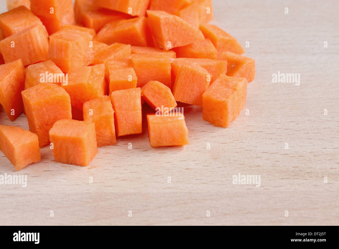 Diced raw carrots on a chopping board Stock Photo