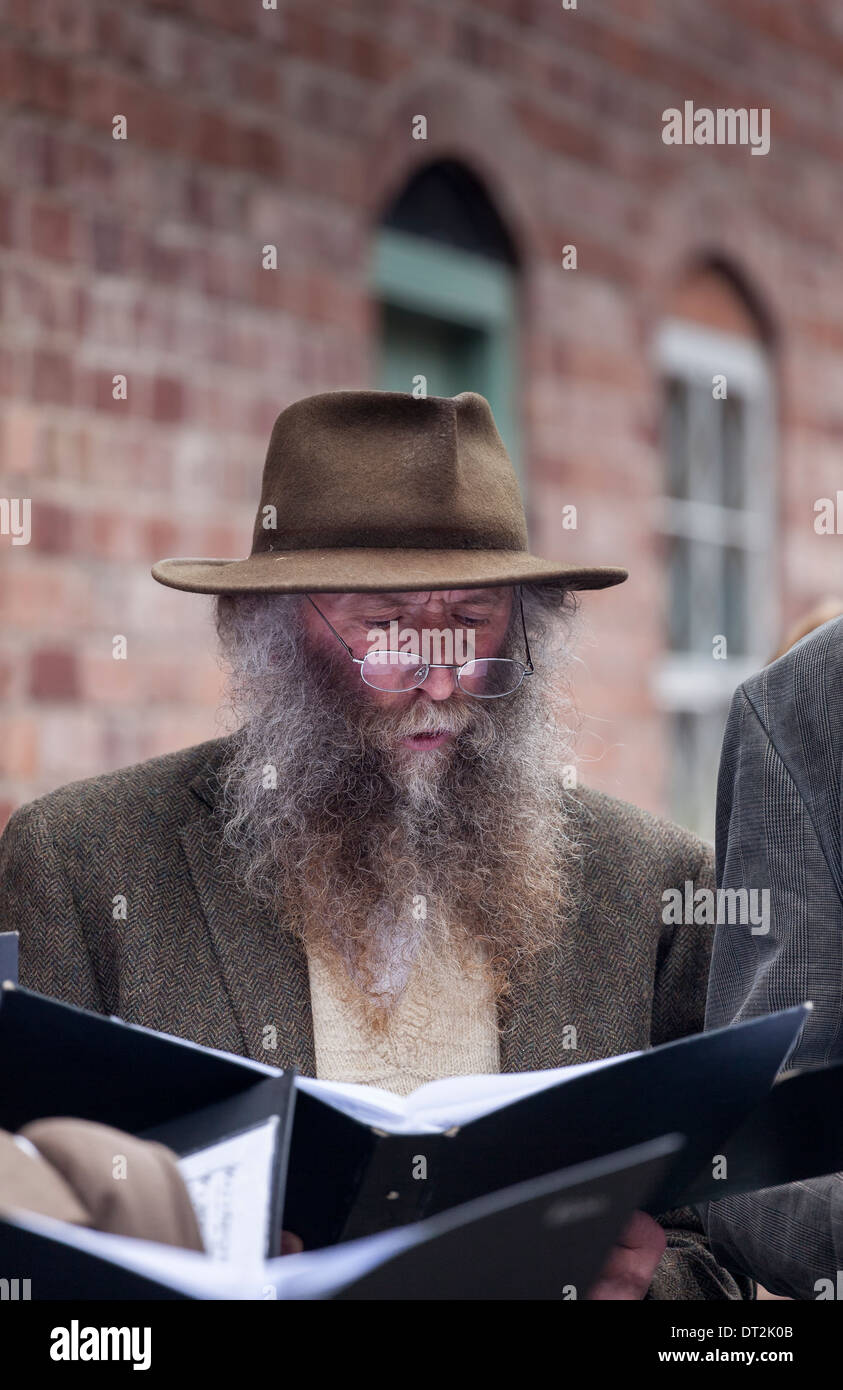 Man With large beard and trilby hat singing songs as part of the 1940s night celebrations at Blists Hill Telford England U.K Stock Photo