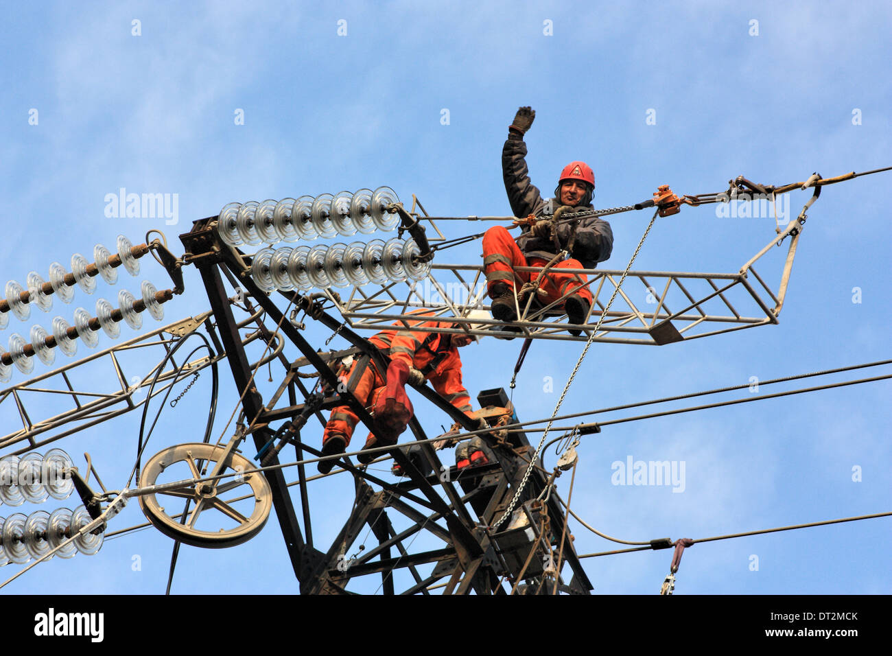 Workers at electricity pylons in Italy. Maintenance work of a high-voltage power line. Stock Photo