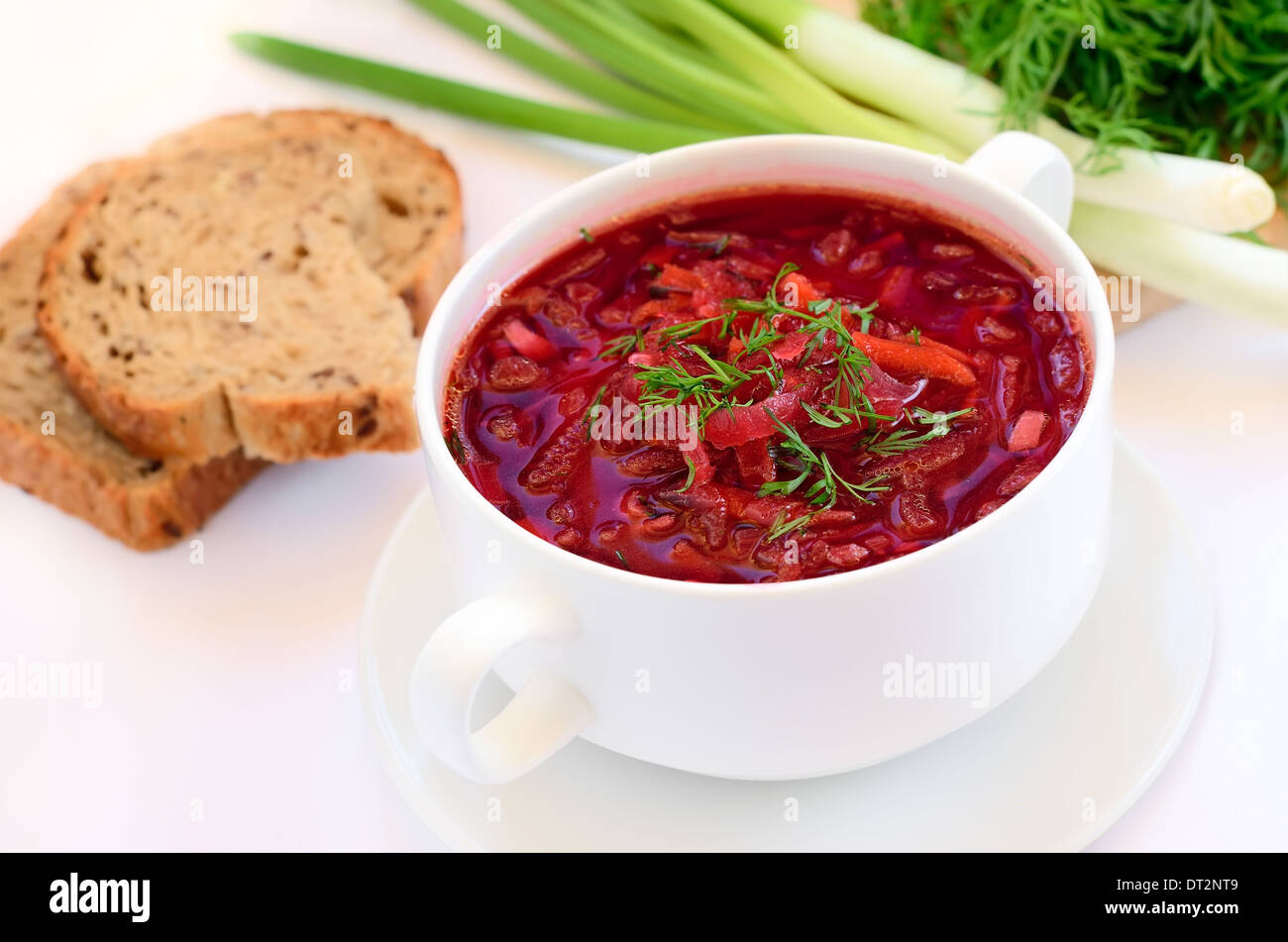 Red borscht soup with dill in white bowl Stock Photo