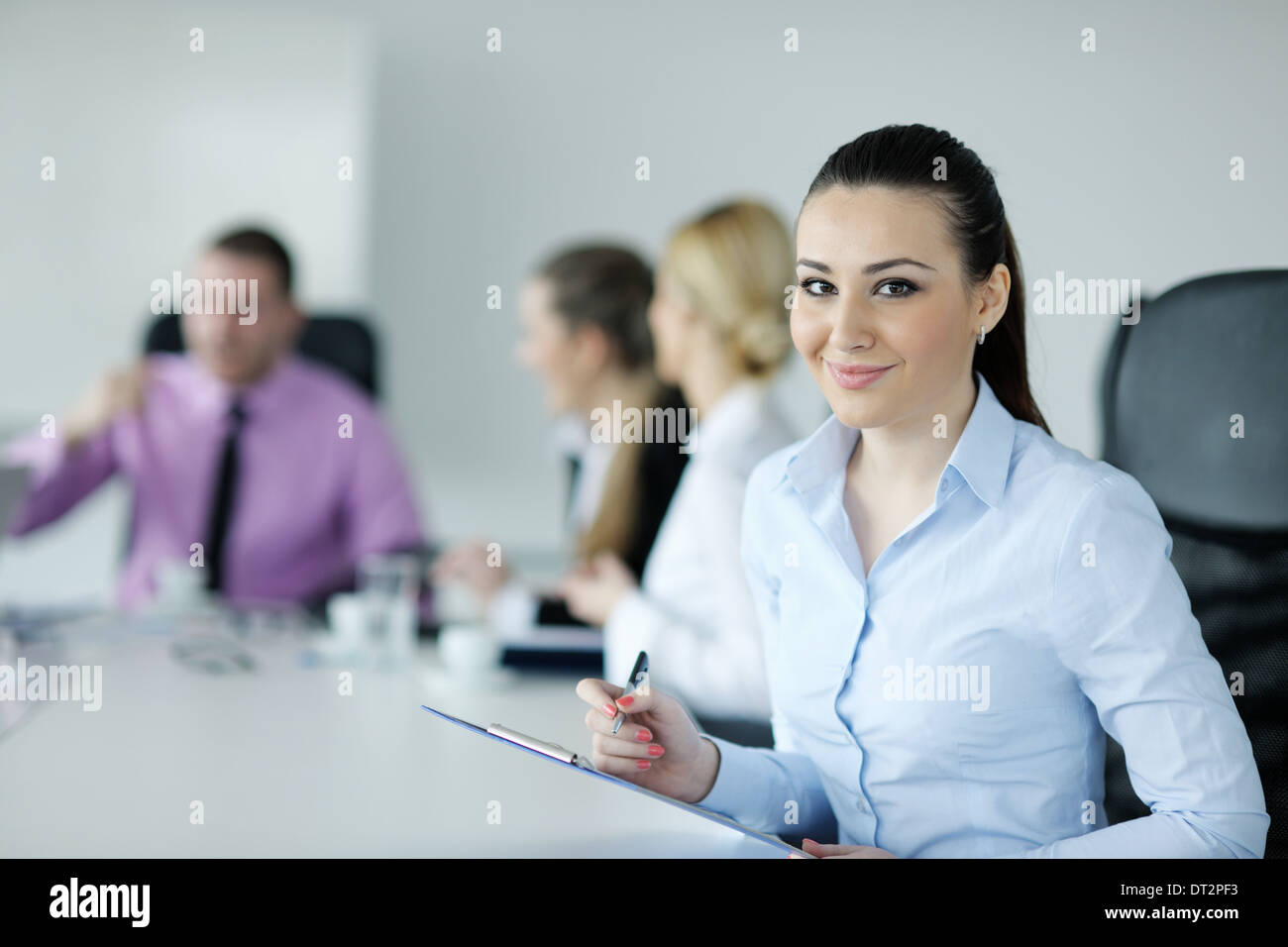 business woman standing with her staff in background Stock Photo