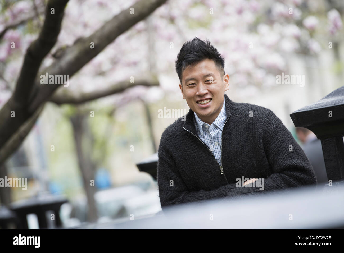 View over cityA young man outdoors in a city park Sitting on a bench Stock Photo