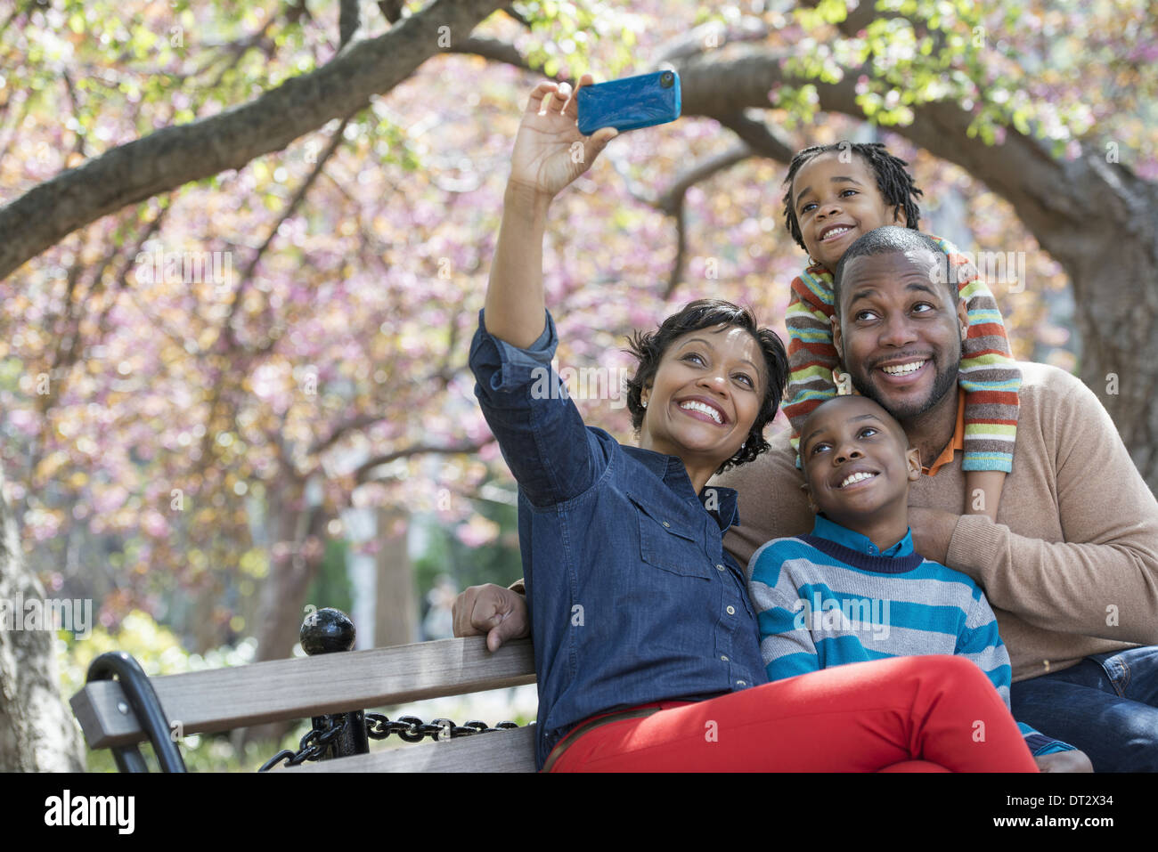 Cherry blossom A woman taking a selfy picture with her smart phone of her family Stock Photo