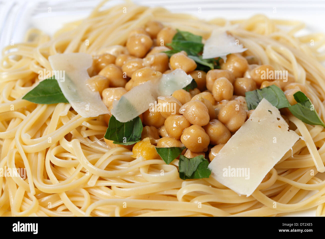 Bavette pasta (like linguine)  with a chickpea, garlic, chili and parmesan sauce, and garnished with torn basil leaves Stock Photo