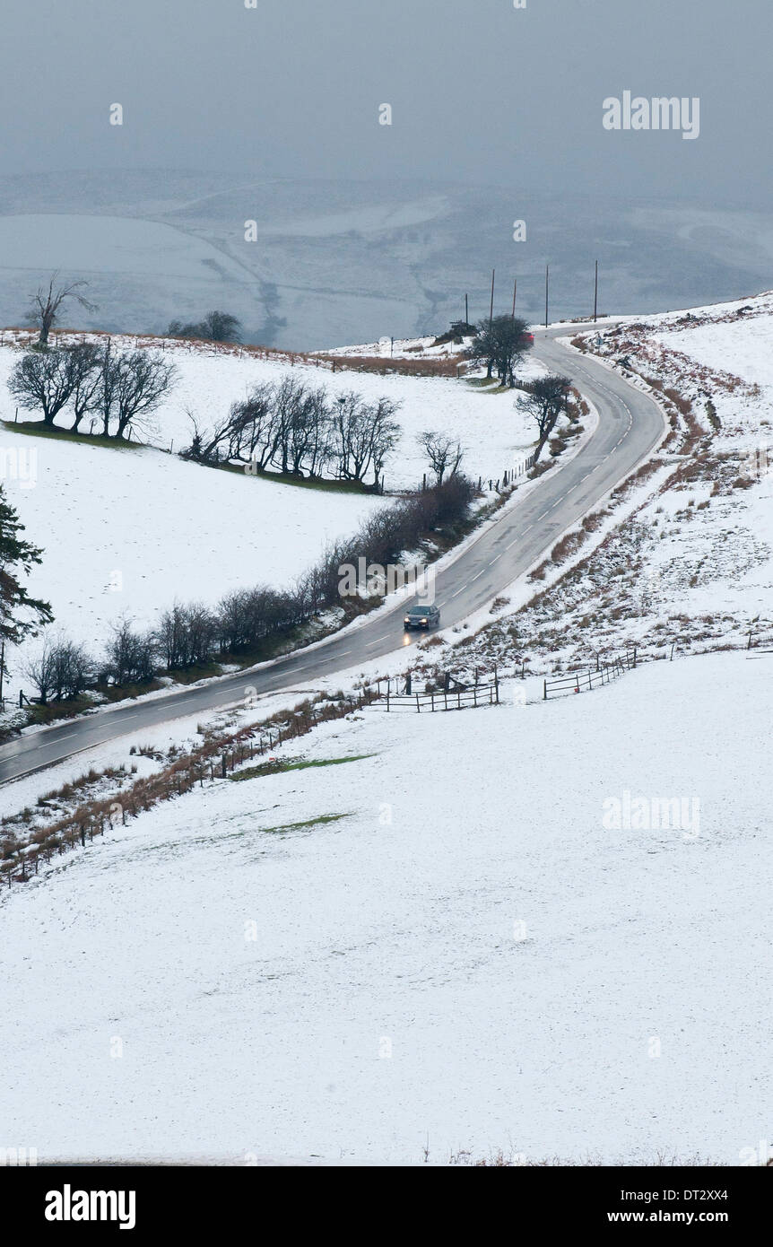Mynydd Epynt, Powys, Wales, UK. 7th February 2014. vehicles negotiate the snowy road between Builth Wells and Brecon under ominous skies . Snow fell last night on high land in Mid-Wales. Credit:  Graham M. Lawrence/Alamy Live News. Stock Photo