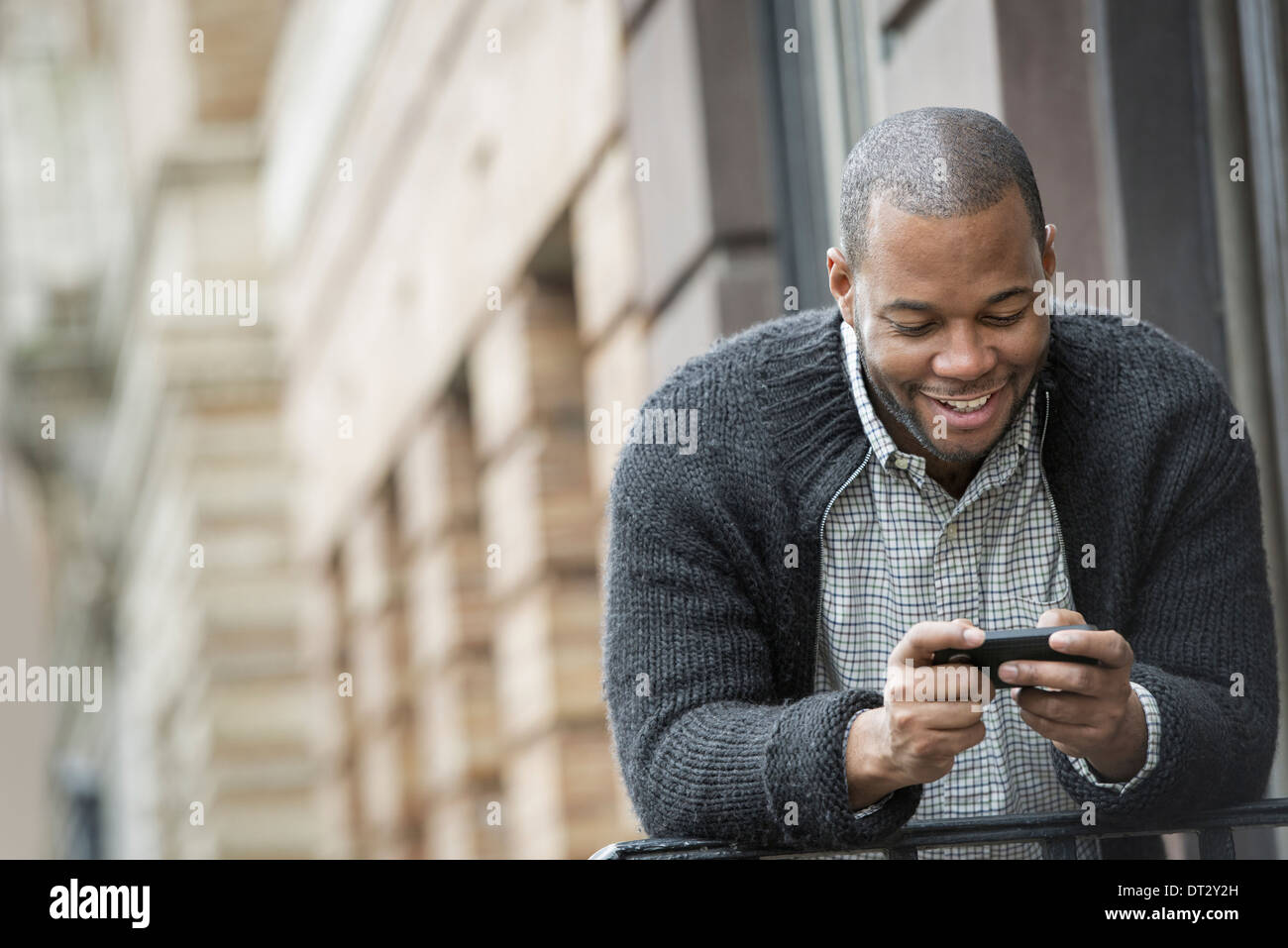 A young man checking his phone and texting Stock Photo