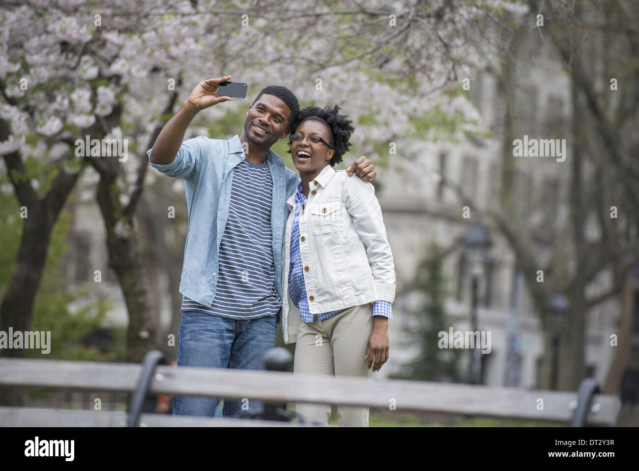 A couple side by side taking a photograph with a smart phone Stock Photo