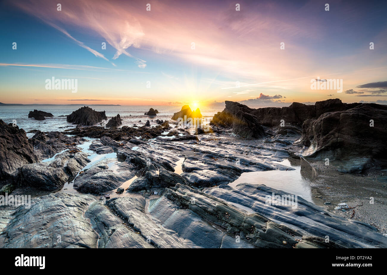 Ocean sunrise on a rocky beach at Looe in south Cornwall Stock Photo