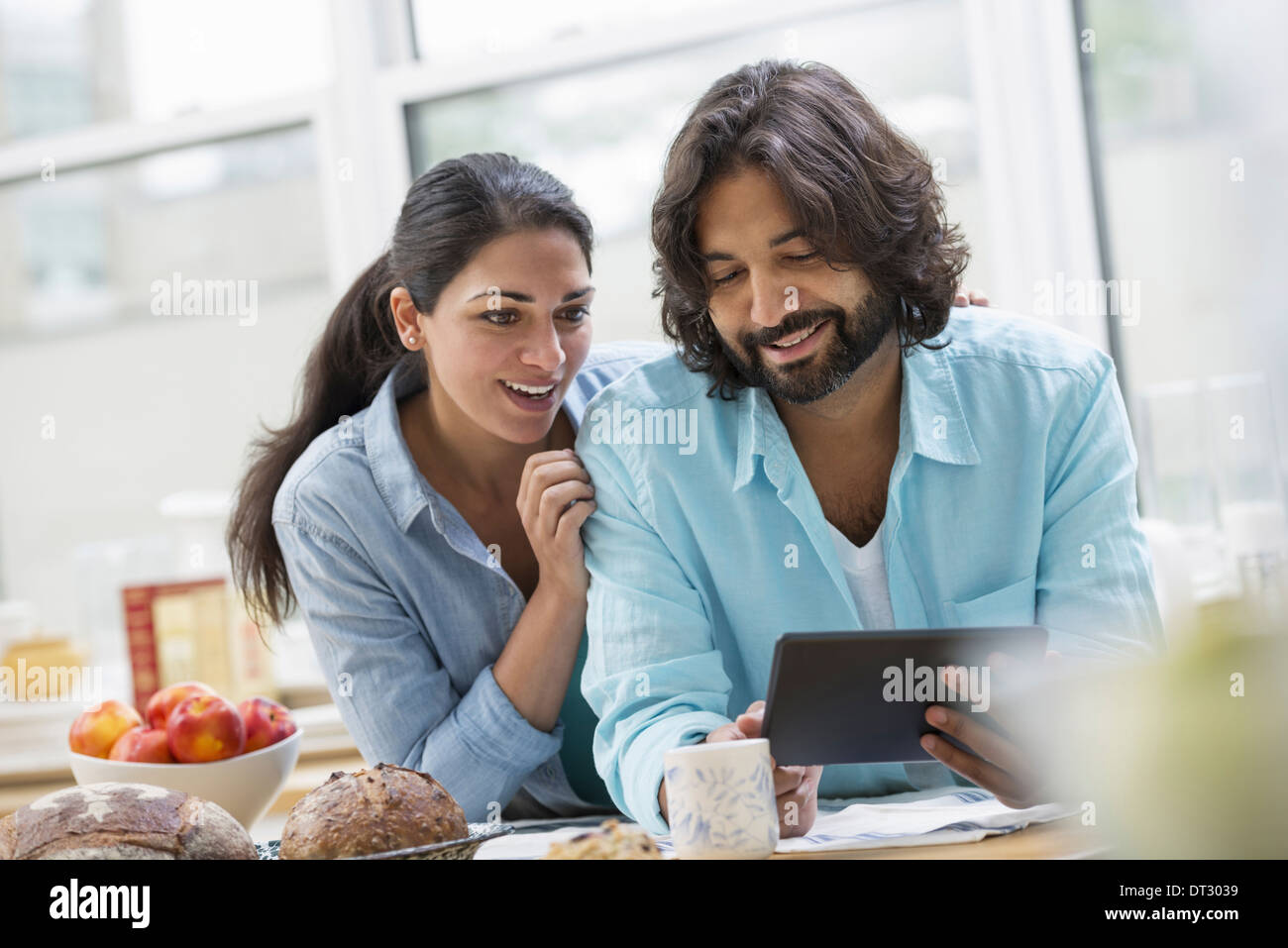 An office or apartment interior in New York City A couple side by side by the breakfast bar Food and fresh fruit Stock Photo