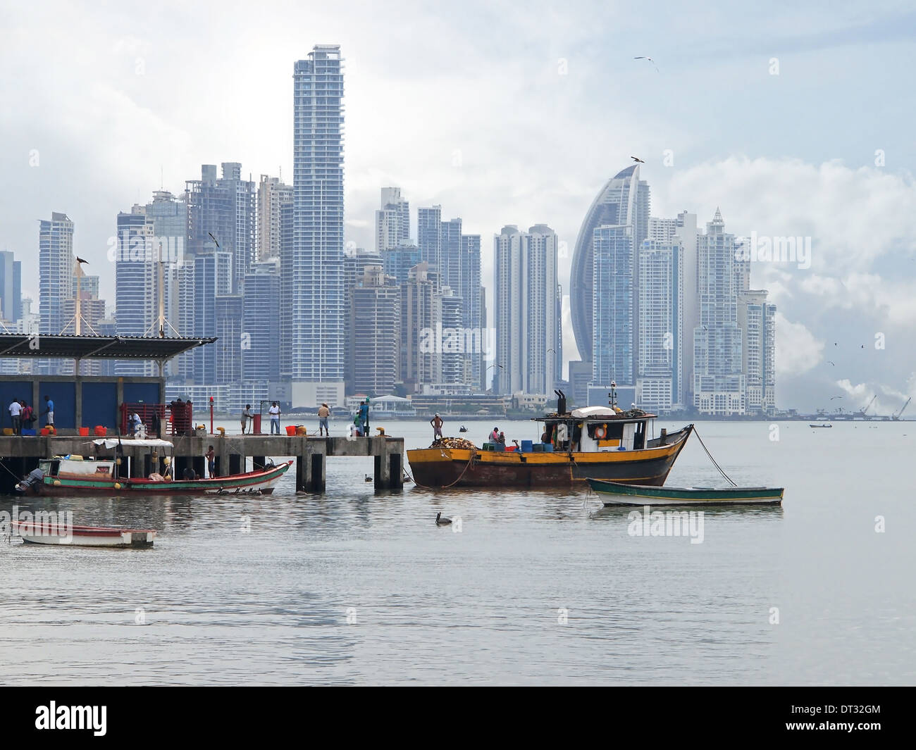 Wharf with fishing boats in foreground and skyscrapers in background, Panama City , Panama, Central America Stock Photo