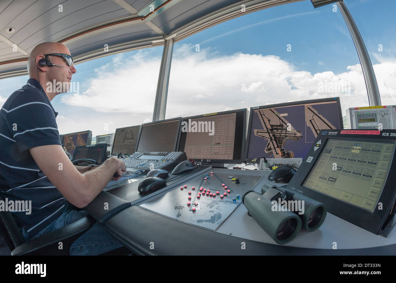 An air traffic controller in the control tower of Zurich/Kloten international airport is monitoring the airport's airfield. Stock Photo