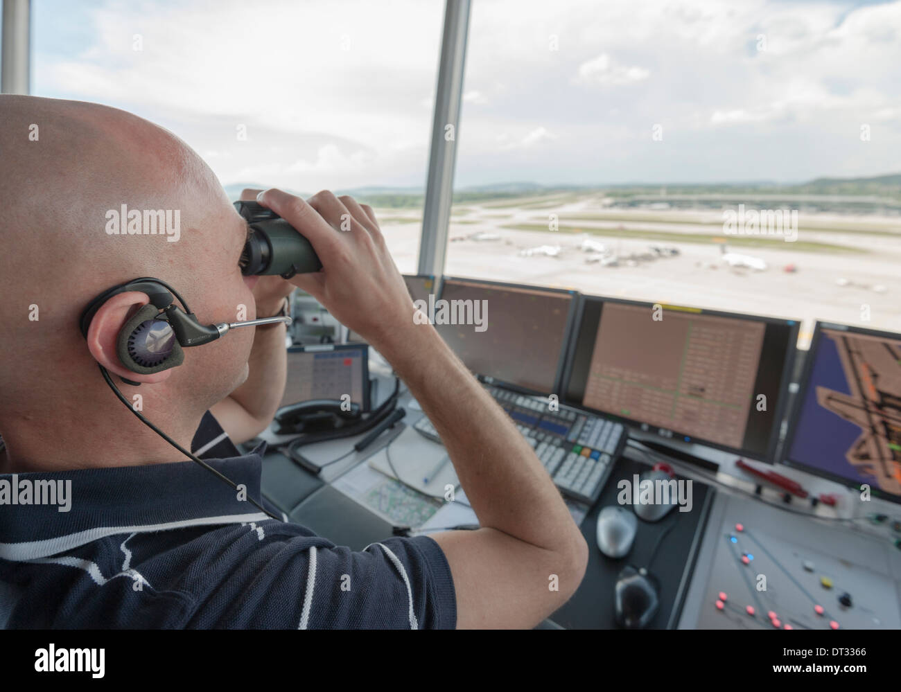 An air traffic controller in the control tower of Zurich/Kloten international airport is monitoring the airport's airfield. Stock Photo