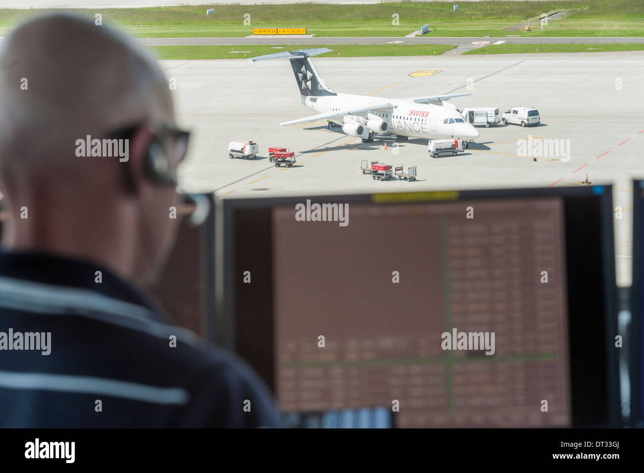 An air traffic controllers in the control tower of Zurich/Kloten international airport is monitoring the airport's airfield. Stock Photo